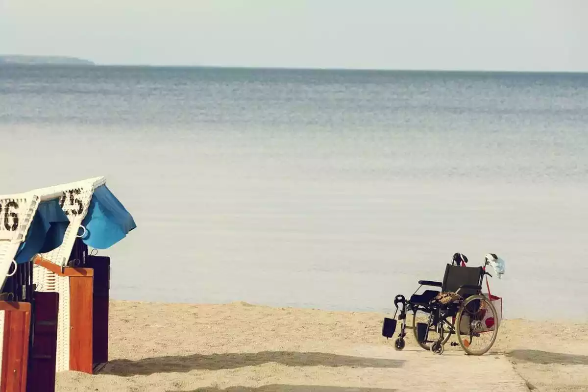 Una silla de ruedas frente a la arena de una playa