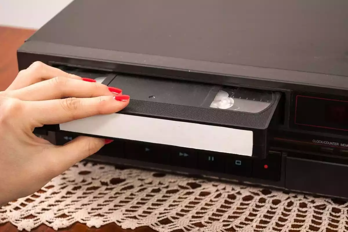 Una mano introduciendo una cinta VHS en un reproductor