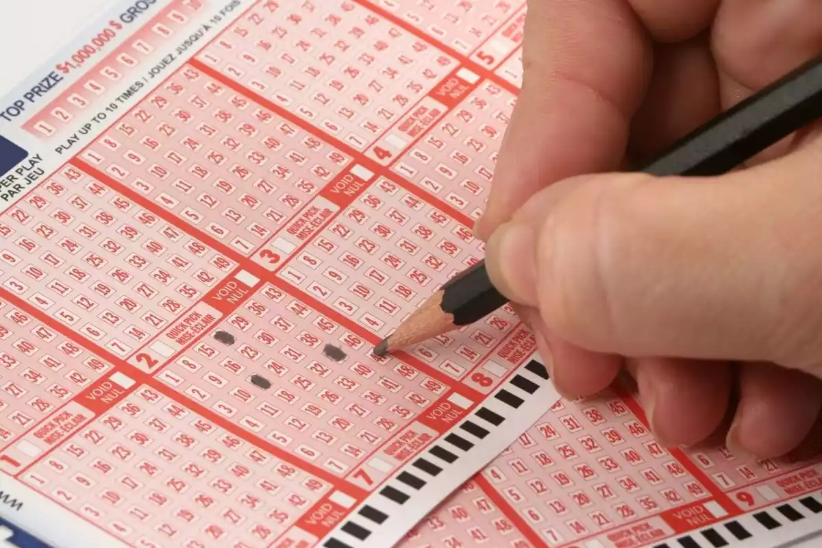 Primer plano de una mano realizando una apuesta de lotería