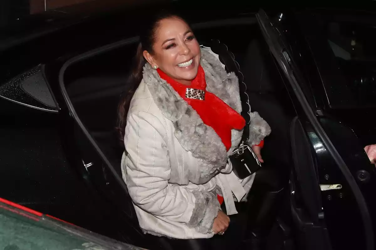 Isabel Pantoja muy sonriente bajando de un coche