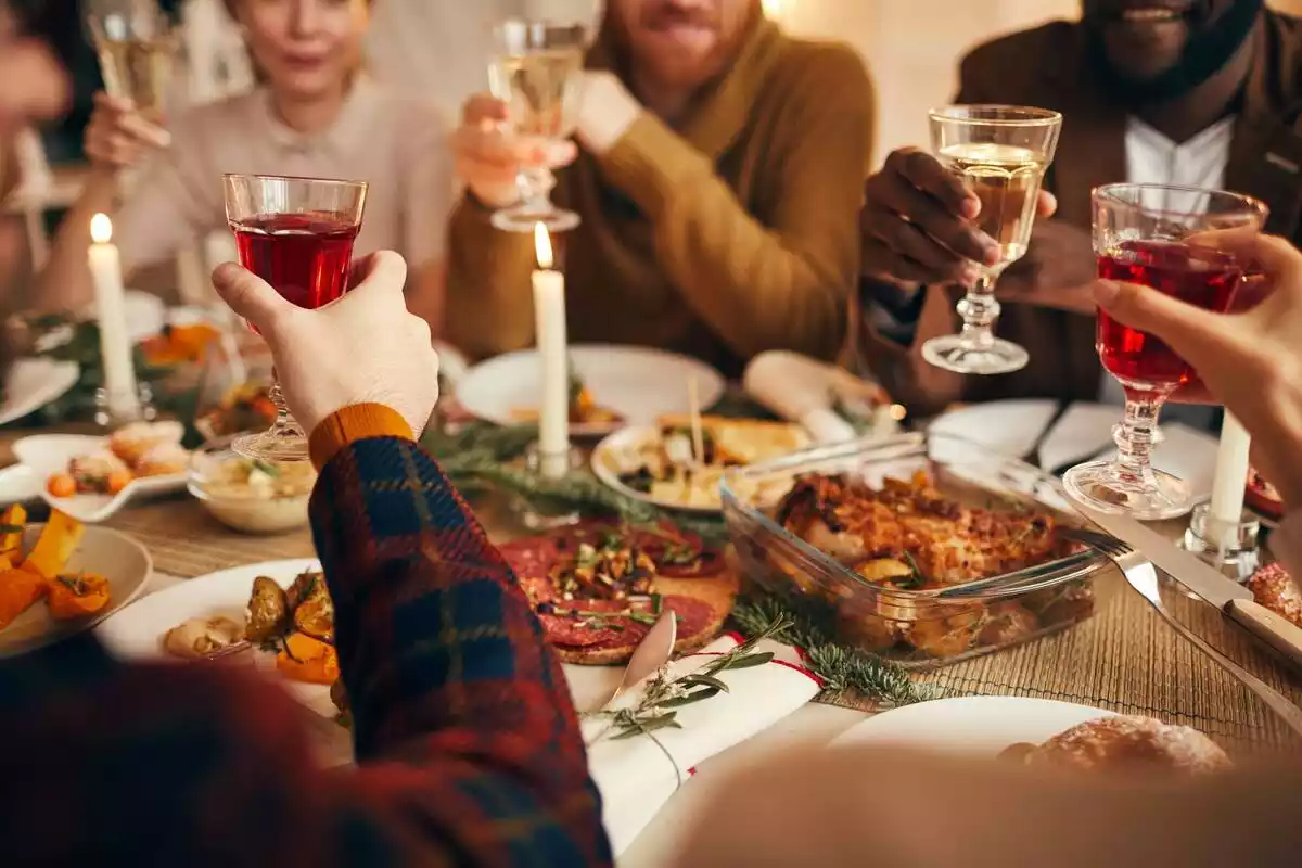 Varias personas alrededor de una mesa en una comida de Navidad