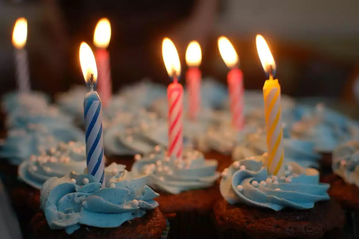 Cupcakes con velas de cumpleaños encendidas encima