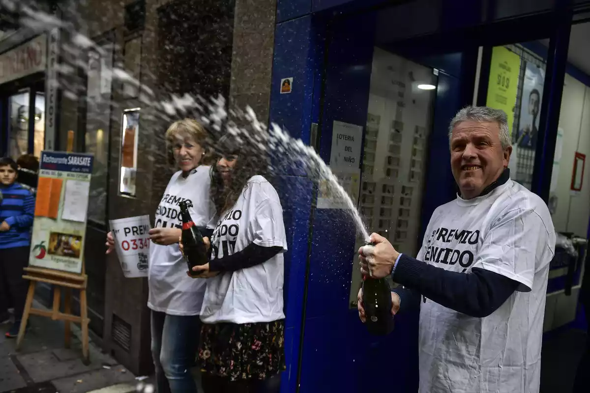 Un hombre destapa una botella de cava para celebrar que les ha tocado la lotería
