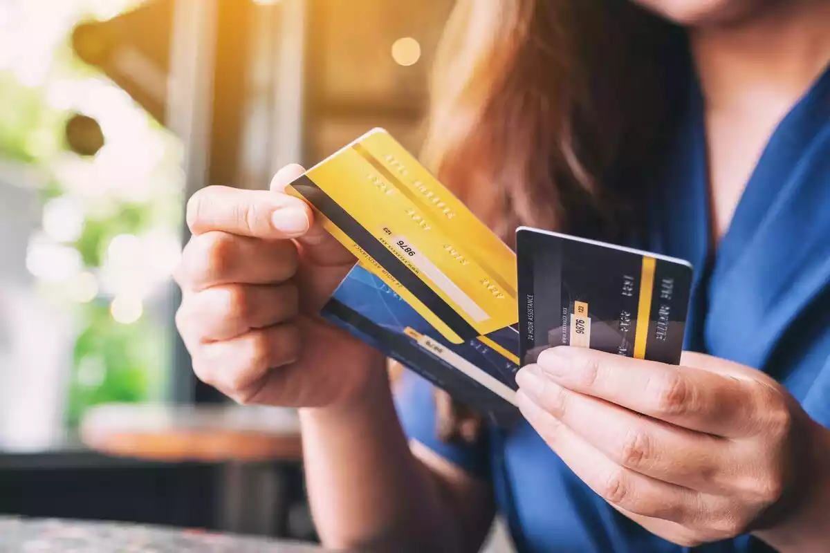 Una mujer sostiene varias tarjetas bancarias en las manos