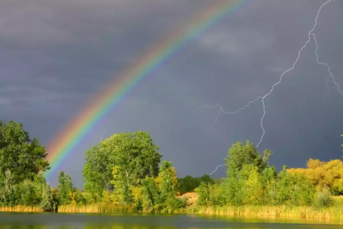 Imagen de un arcoríris y la caída de un rayo