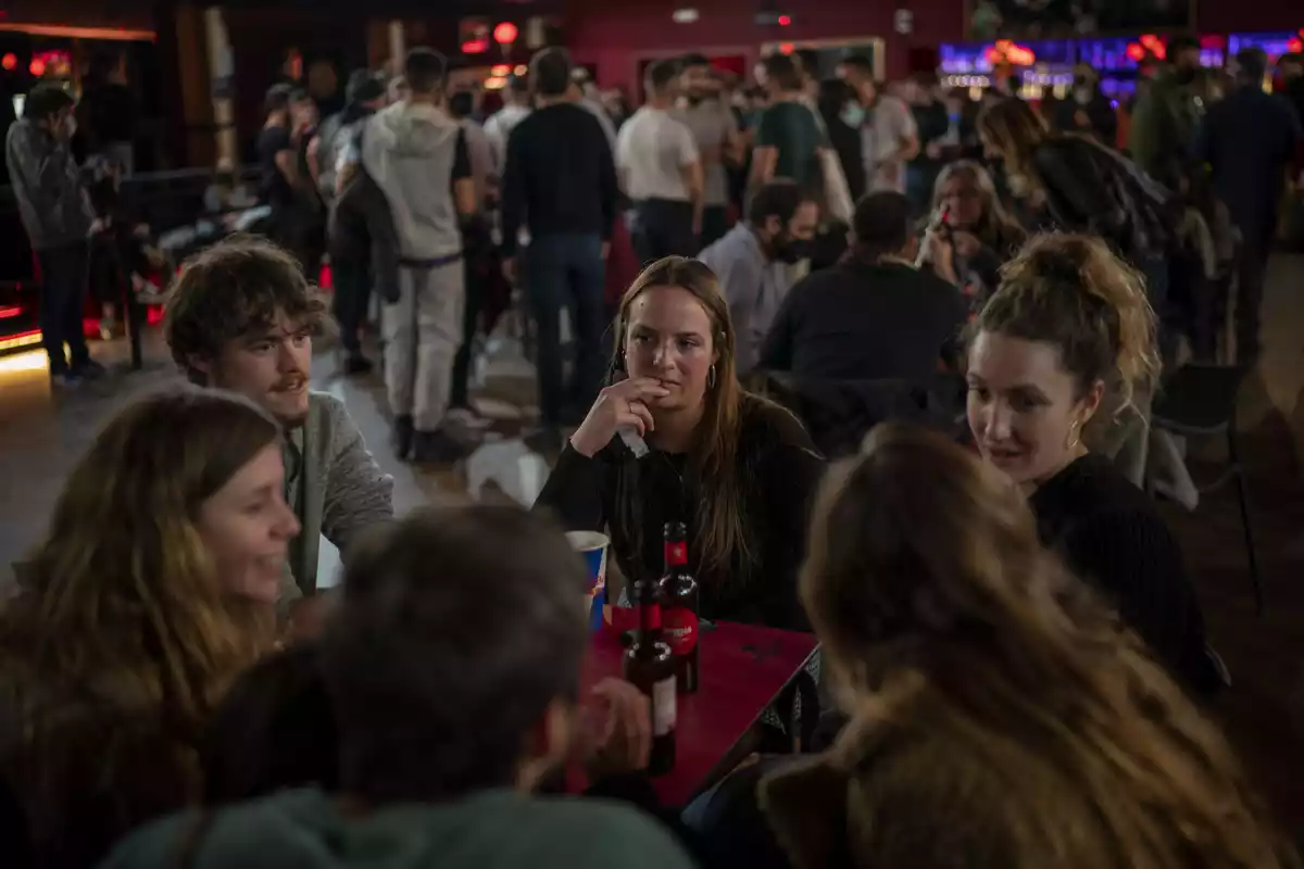Varias personas bebiendo cerveza en una mesa de un bar en Barcelona en diciembre del 2020